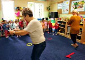 Nauczycielki biorą udział w zabawie zręcznościowej - przenoszenie piłeczek