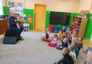 Dzieci słuchają informacji na temat instrumentów muzycznych
