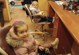 Dziewczynka siedzi na fotelu fryzjerskim