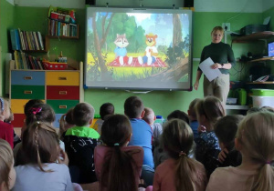 Dzieci słuchają listu od Kubusia czytanego przez nauczycielkę