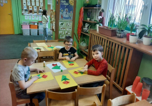 Dzieci wykonują kwiaty metodą origami.