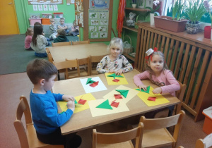 Dzieci wykonują kwiaty metodą origami.