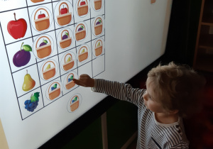 Dziecko rozwiązuje zadania na tablicy interaktywnej