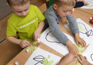 Dzieci wyklejają owoce bibułą