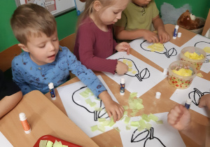 Dzieci wyklejają owoce bibułą