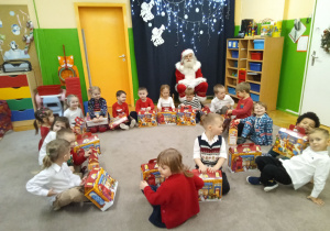 Zdjęcie dzieci z prezentami i Mikołajem