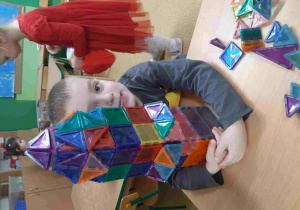 Chłopiec buduje wieżę z klocków