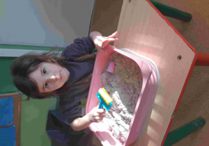 Dziewczynka bawi się w piasku kinetycznym